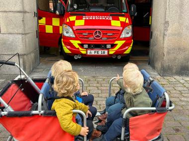 Børn i klapvogn kigger på brandbil